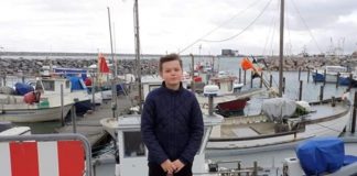 Frederik Larsen placerer jubilæumssten ved Jollehavnen